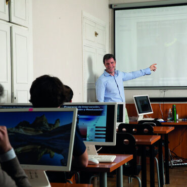 Profesor frente a pantalla impartiendo curso