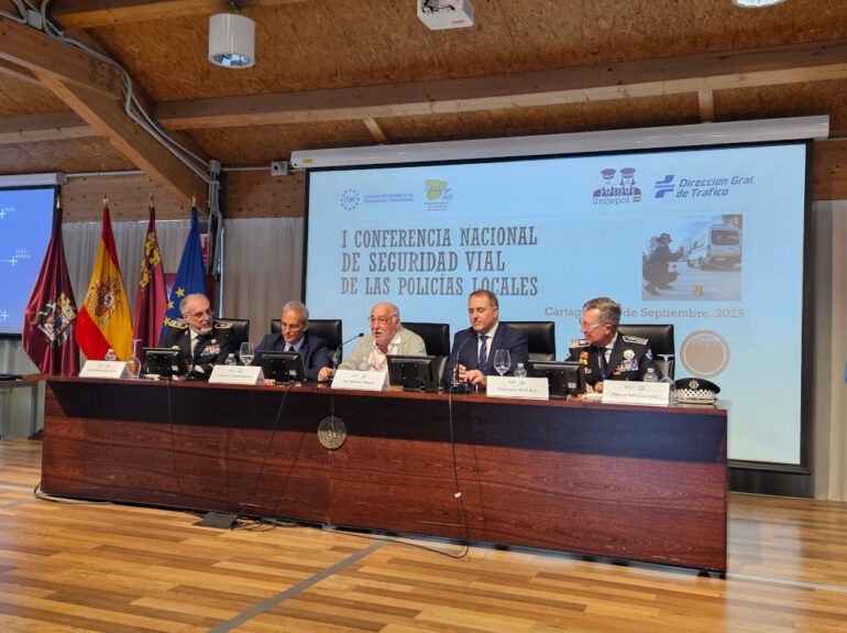 Mesa inaugural de la I Conferencia Nacional de Seguridad Vial de las Policías Locales en Cartagena, con cinco ponentes uniformados y autoridades sentados frente a un cartel proyectado con el título del evento