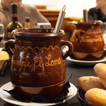 Orzas de barro del Restaurante El Lomo sirviendo cocido manchego tradicional con pan y vino en Albacete